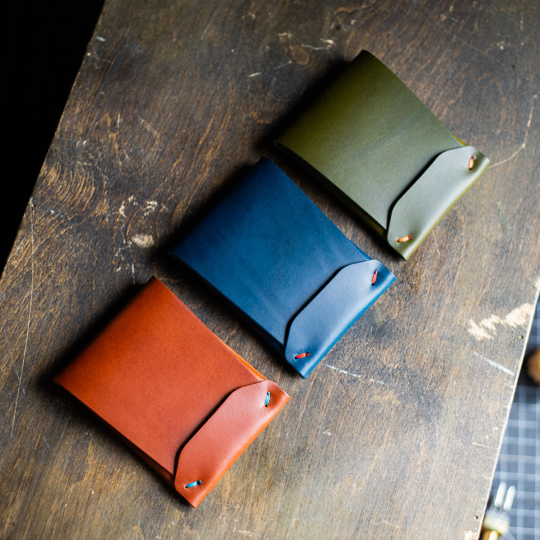 Brown, Blue, Olive Archer Wallet on a brown crafting table