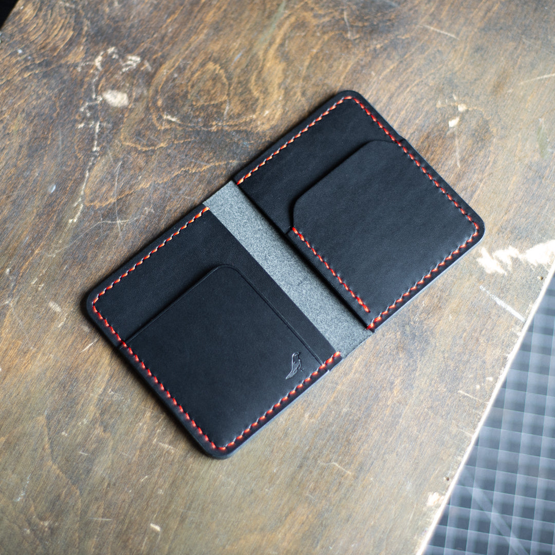 Red and Black Pattern - Garrison Wallet displayed on a brown table