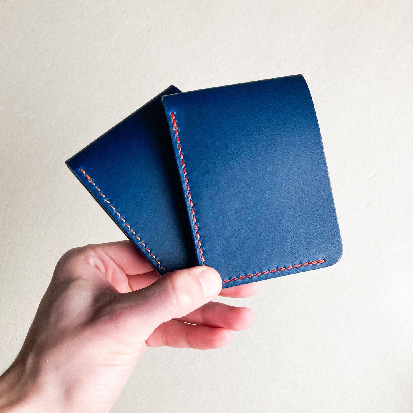 Two Closed Blue Pattern - Kingston Wallet held by a man against a white blurred background.