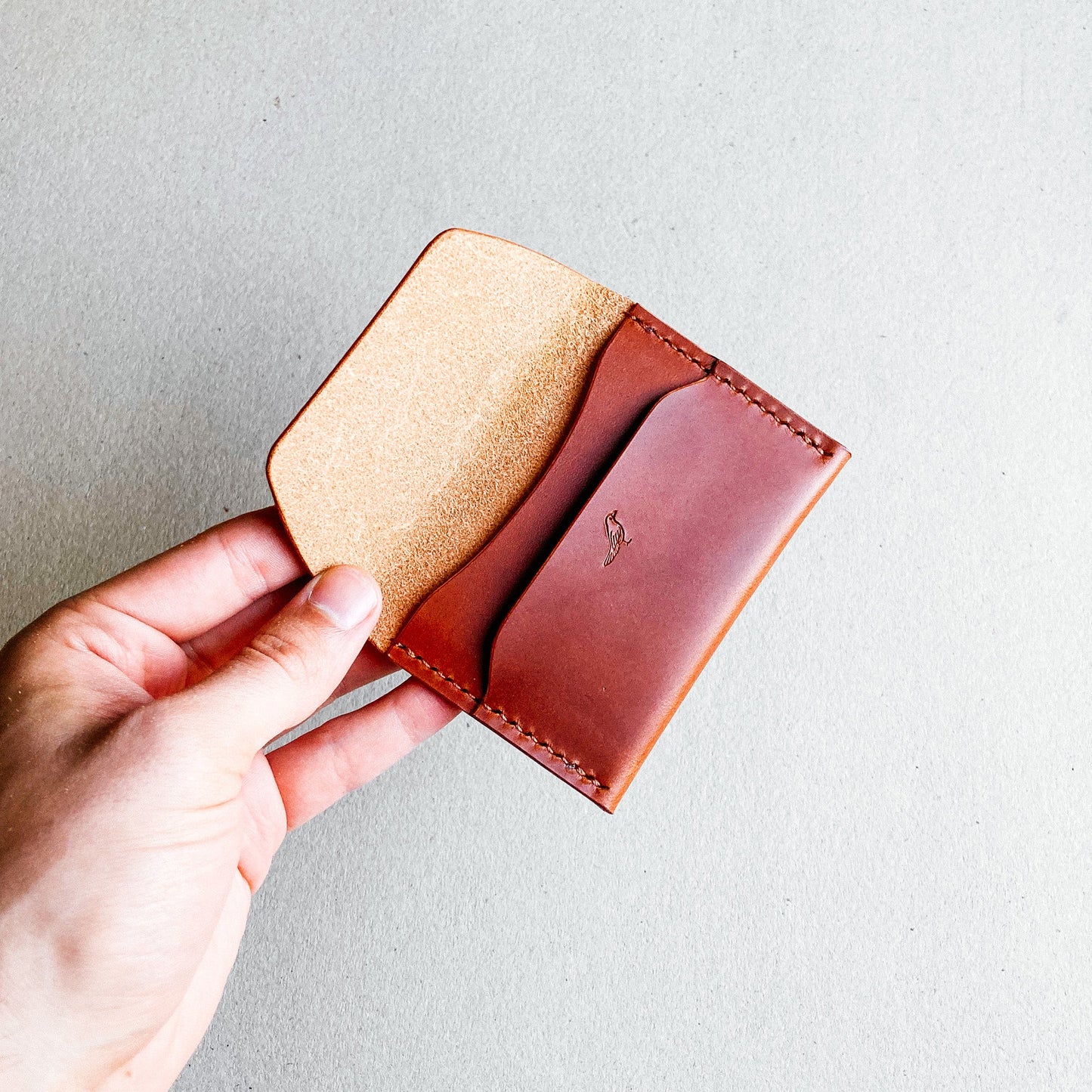 Opened Brown Pattern - Warden Wallet held by a man against a blurred background.