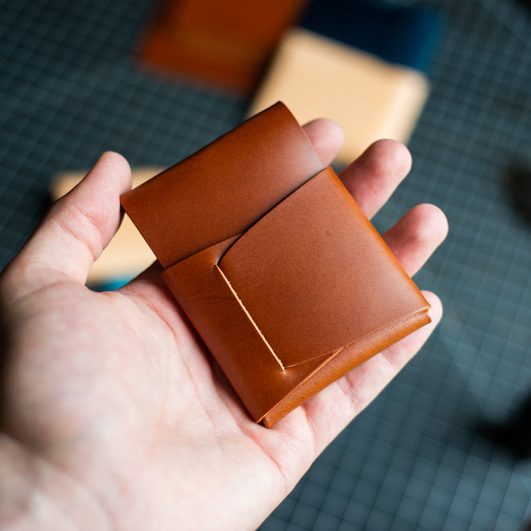 View from the back: Brown Cash Emerson Wallet neatly filled with bills and cards on a workbench