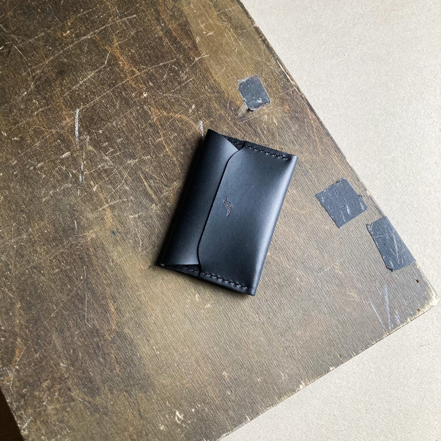 Closed Black Pattern - Warden Wallet displayed on a brown table.