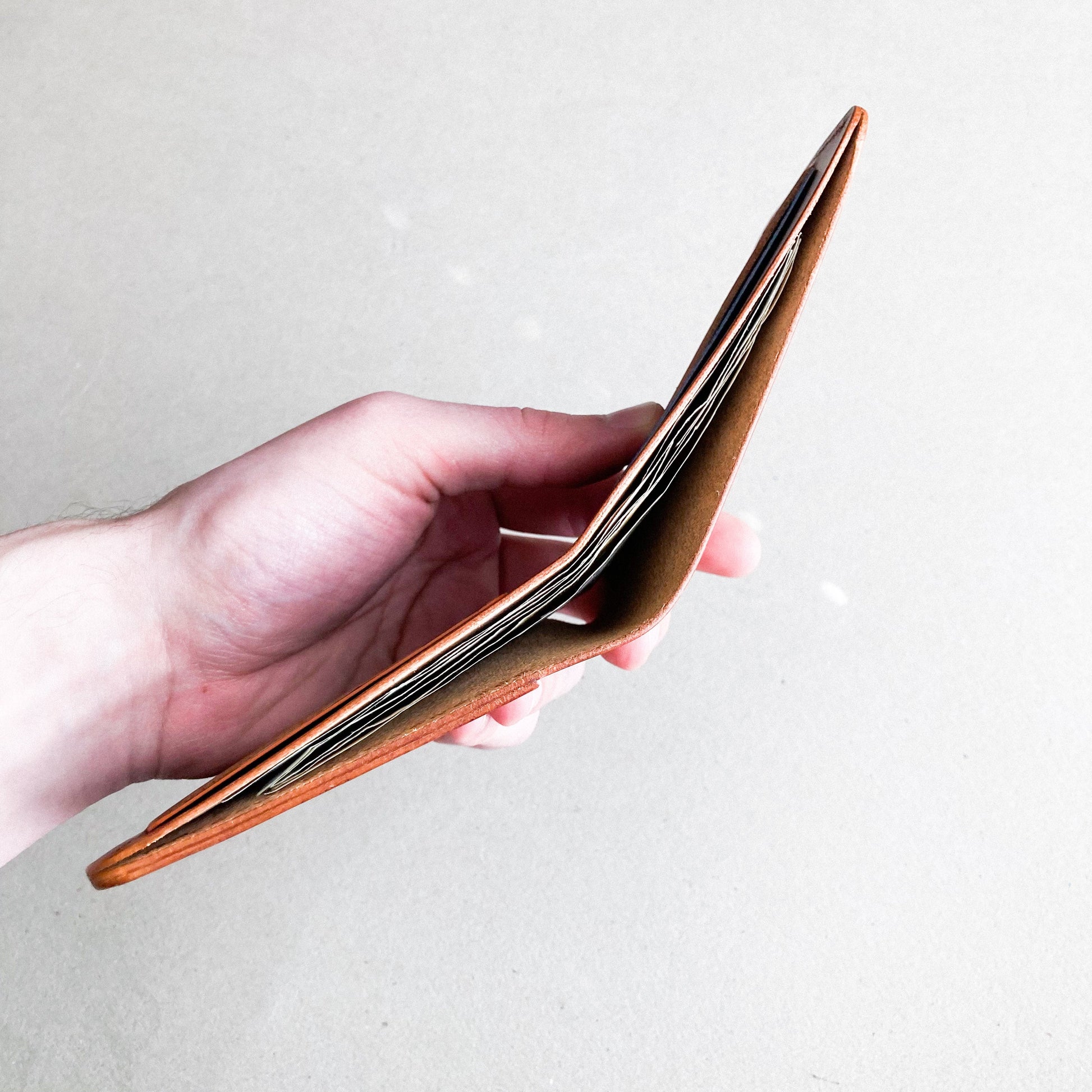 Opened Brown Pattern - Kingston Wallet held by a man against a white blurred background.