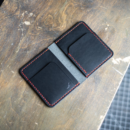 Red and Black Pattern - Garrison Wallet displayed on a brown table