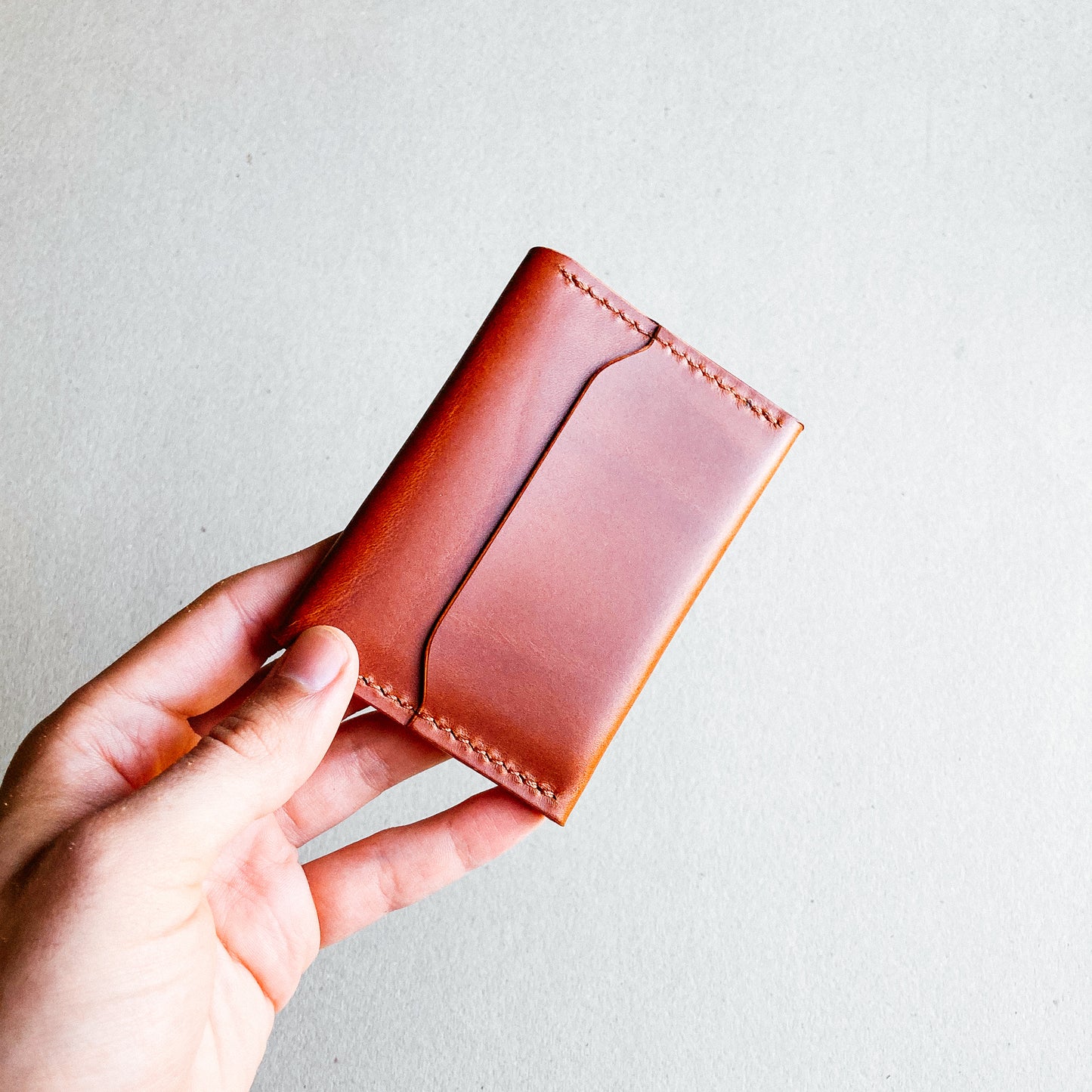 Closed Brown Pattern - Warden Wallet held by a man against a blurred background viewed from back