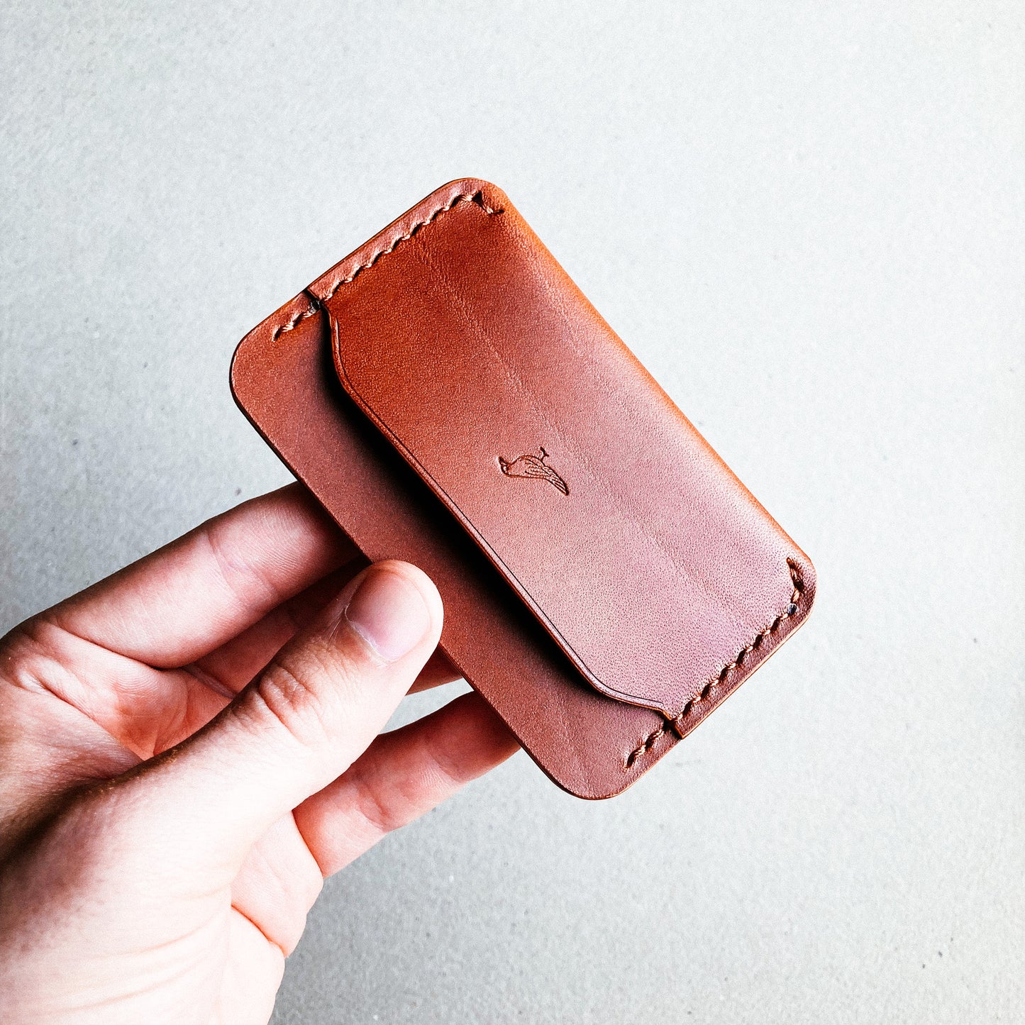 Brown Pattern - Erikson Wallet held by a man against a white blurred background.