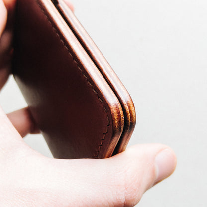 Opened Light Brown Garrison Wallet held by a man against a blurred background close view from the side